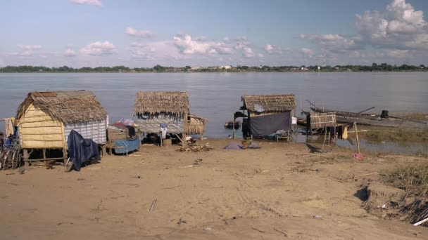 Vissersdorp met huisjes op palen en strodaken aan de rand van de rivier — Stockvideo