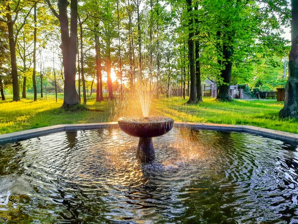 Park çeşmesi batan güneşin kırmızı ışığıyla aydınlandı.
