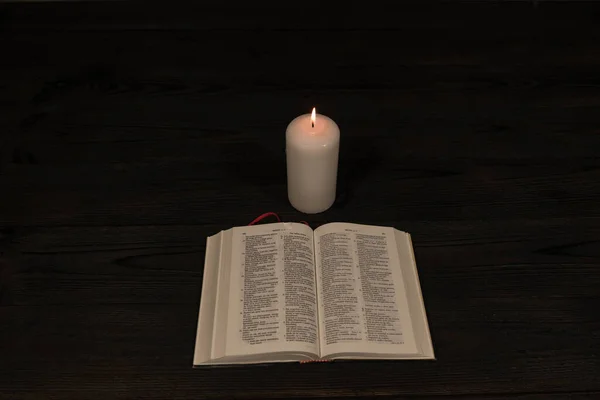 Bible Lying Dark Wooden Background Lit Warm Light Flame Standing — Stock Photo, Image