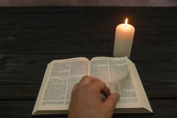 Biblia Leżąca Ciemnym Drewnianym Tle Oświetlona Ciepłym Światłem Płomienia Stojącego — Zdjęcie stockowe
