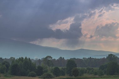 Ovadaki tarlalar ve çayırlar. Ufuktaki Karkonosze Dağlarının sisli zirveleri.