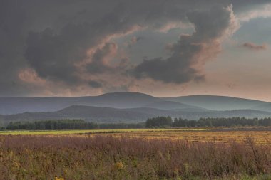 Ovadaki tarlalar ve çayırlar. Ufuktaki Karkonosze Dağlarının sisli zirveleri.