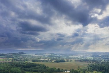 Ovadaki tarlalar ve çayırlar. Ufuktaki Karkonosze Dağları 'nın sisli zirveleri. İnsansız hava aracından görüntüle.