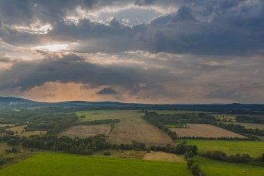 Ovadaki tarlalar ve çayırlar. Ufuktaki Karkonosze Dağları 'nın sisli zirveleri. İnsansız hava aracından görüntüle.