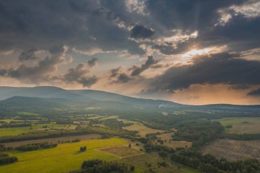Ovadaki tarlalar ve çayırlar. Ufuktaki Karkonosze Dağları 'nın sisli zirveleri. İnsansız hava aracından görüntüle.