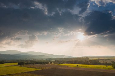 Ovadaki tarlalar ve çayırlar. Ufuktaki Karkonosze Dağları 'nın sisli zirveleri. İnsansız hava aracından görüntüle.