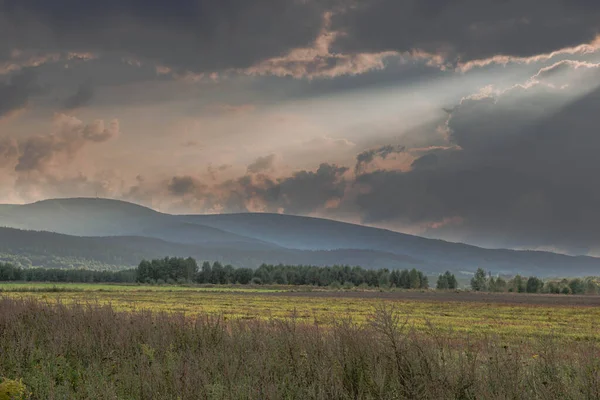 Ovadaki tarlalar ve çayırlar. Ufuktaki Karkonosze Dağlarının sisli zirveleri.