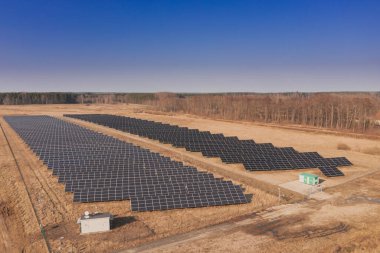 Kahverengi topraklarda bir güneş paneli çiftliği. Güneşli bir gün. Drone fotoğrafı.