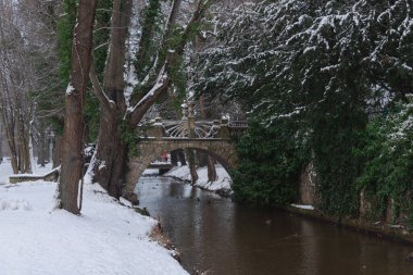 Czerna Maa Nehri Polonya 'nın Iowa kentindeki malikane parkından akar. Köprüler ve yaya köprüler nehrin üzerinde görülebilir. Kış mevsimindeyiz ve kar zemini kaplıyor..