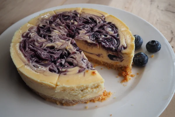 Beyaz çanak üzerinde yaban mersinli cheesecake