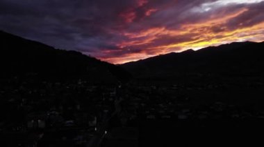 Avusturya 'nın Kaprun şehrinin siluetli manzarasında akşam gökyüzünde renkli bir gün batımı. - Zaman aşımı, İHA