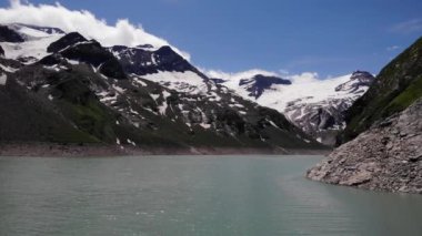 Avusturya, Kaprun 'daki Stausee Wasserfallboden Gölü kıyısında engebeli dağlar. - Geniş açı