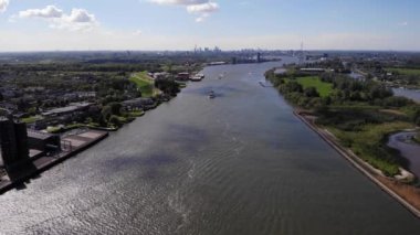 Hollanda 'daki Kinderdijk kasabasında gökdelenler ve yeşil alan nehrin etrafını sarar. hava durumu