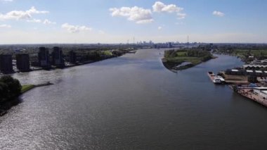Güney Hollanda, Molenlanden 'deki Kinderdijk Köyü' nde nehir kenarındaki gökdelenlerle birlikte gün ışığının yansıması. hava durumu