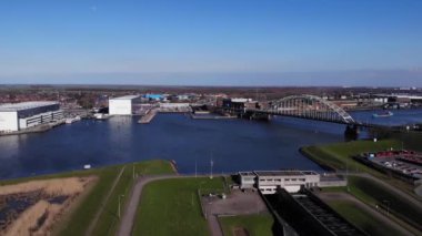 Arka planda mavi gökyüzü ile Noord Nehri 'nde uzanan kemer köprüsünün hava görüntüsü. 