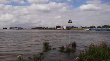 İç nakliye gemisinin arka plandan geçmesiyle nehir üzerinde hava yükselişi