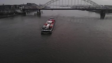 Hollanda kargo mavnası, arkasında basküle köprüsü olan bir Hollanda nehri Noord 'unda yol alan konteynırlarla dolu. Drone kamyonu vuruldu.