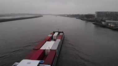 Kasvetli bir günde Noord Nehri 'nden geçen içi konteynır dolu bir kargo gemisi. - Yüksek açı