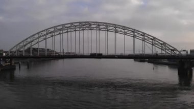 Hollanda, Alblasserdam 'daki Noord Nehri üzerindeki kemer köprüsünden geçen araçlar. - Havadan çekim.