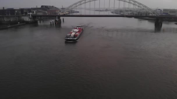 货船载着许多集装箱 航行在通过一个玄武岩桥的Noord支流河上 慢速无人驾驶卡车射击 — 图库视频影像