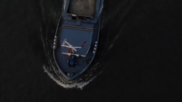 在暮色的冬日里 一艘满载货物的驳船在内陆的一条河里全速前进 无人机从上面发射 — 图库视频影像