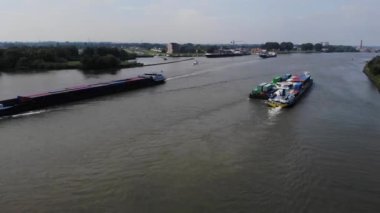 Hollandalı bir nehirde birbirinin yanından geçen bir sürü mavna.