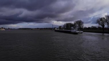 Hollanda 'da Puttershoek yakınlarında seyahat eden gemi ile Sessiz Oude Maas Nehri üzerindeki bulutlu gökyüzü. - Geniş açı