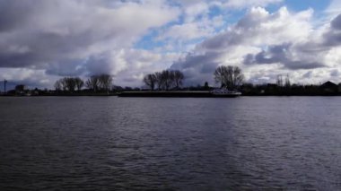 Hollanda 'nın güneyindeki Puttershoek kasabasında, Oude Maas' ın üstünde bulutlu bir gökyüzü ve kanal gezisi. geniş hava görüntüsü