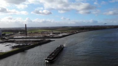 Hollanda, Puttershoek yakınlarındaki eski bacalı Oude Maas Nehri 'nin karşısındaki yük mavnası. - Hava.