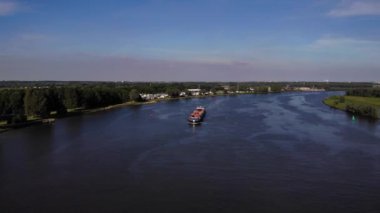 Hollanda 'nın Barendrecht kasabasındaki Oude Maas Nehri' nde seyir halindeki Borelli kargo gemisinin uzaktan görüntüsü. hava durumu