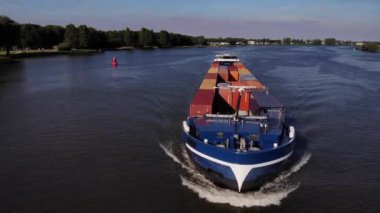 Hollanda, Barendrecht yakınlarındaki Oude Maas Nehri üzerinde hareket eden Intermodal konteynırlarla yüklenen ticaret gemisi. - Havadan çekim. 