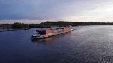 Hollanda, Barendrecht yakınlarındaki Oude Maas Nehri 'nde Intermodal konteynır yığını taşıyan iç nakliye gemisi. - Havadan çekim.