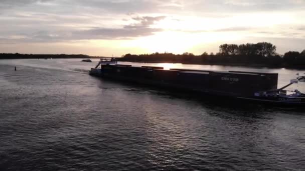 波打つ水にコンテナで積み込まれた荷船オランダ 南オランダのバレンドレヒトにあるバックライト付きの日光 空中射撃 — ストック動画