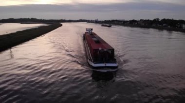 Ham petrol tankeri gün batımında açık deniz altında. Güneş ışığının suya yansıması altın gibi parıldayan bir yüzey yaratır. Hava okyanusu, yakın çekim, doğal ışıklandırma.