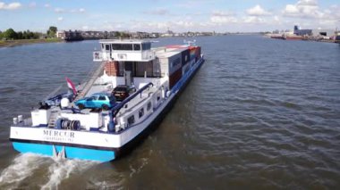 Konteynır gemisi güneşli bir günde Kinderdijk Köyü 'nde seyahat ediyor. hava durumu