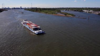 Hollanda, Güney Hollanda 'daki Kinderdijk yakınlarındaki Waterway' de seyyar konteynır dolu bir mavna gemisi. - Havadan çekim.