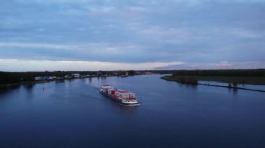 Hollanda, Barendrecht yakınlarındaki Bulutlu Gökyüzü 'ne karşı Oude Maas' ın Nehirdeki Ticari Konteynır Gemisi. - Havadan çekim.