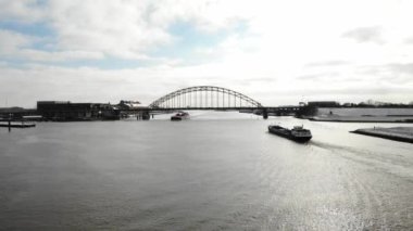 Hollanda 'da Noord Nehri' nin altından geçen yük gemileri bulutlu gökyüzüne karşı. - Havadan Geniş Atış