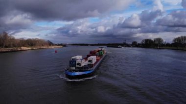 Hollanda 'daki Oude Maas Nehri' nde kargo konteynırları taşıyan sanayi mavnası. - Hava. 