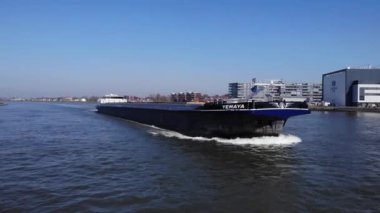 Hollanda 'nın Noord Nehri' ndeki dalgalanan bayraklarının altında yelken açan Aracı Yemaya Kargo Gemisi. - Çekim