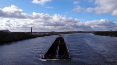 Hollanda 'daki Puttershoek yakınlarındaki Idyllic Oude Maas Nehri' nde içi boş kargo ambarları olan kuru bir kargo gemisi. - Geniş açı