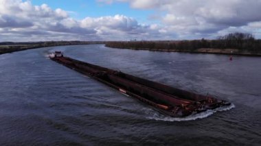 Hollanda 'nın güneyindeki Puttershoek yakınlarındaki Oude Maas Nehri' nden geçen çoklu kargo ambarları olan kuru bir kargo gemisi. - Havadan çekim.