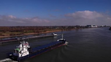 Hollanda, Güney Hollanda 'daki Oude Maas Nehri' nden geçen boş kargo gemileri güneşli bir günde. İHA yörüngesi