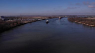 Yük gemisi nehre doğru yol alıyor. Su ve hava manzaralı ticaret kavramı