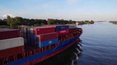 Hollanda 'da nehirdeki bir kargo gemisiyle taşınan malların konteynırları. hava durumu