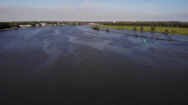 Hollanda 'daki Huzur Nehrinin Manzarası. Uzaktan yaklaşan büyük bir konteyner gemisi var. hava durumu