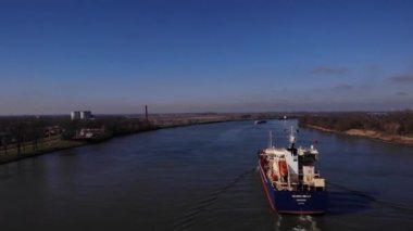 Yük gemileri suda. Nehrin yukarısındaki hava manzarası. Drone yükseliyor.