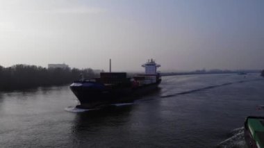 Yük gemileri suda. Nehrin yukarısındaki hava manzarası. Drone yükseliyor.