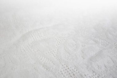 Klasik desenli masa örtüsü, beyaz kumaş perde arkası.