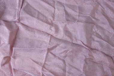 Pembe ipeksi kumaş, gölgelerle buruşmuş, yumuşak odak  